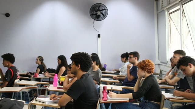 Candidatos sentados em sala de aula durante prova de concurso público