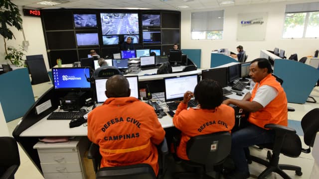 Operadores da Defesa Civil de Campinas monitoram câmeras de segurança em central de monitoramento