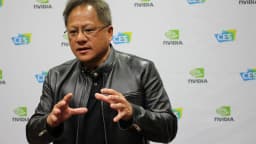 O CEO da Nvidia, Jensen Huang, gesticula durante evento com o logotipo da empresa ao fundo