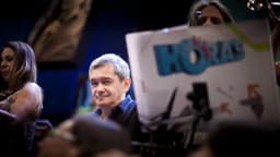 Serginho Groisman sorrindo, com microfone, em evento público