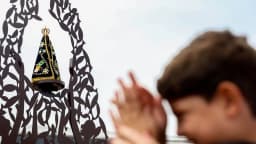 Criança reza diante de uma imagem de Nossa Senhora Aparecida