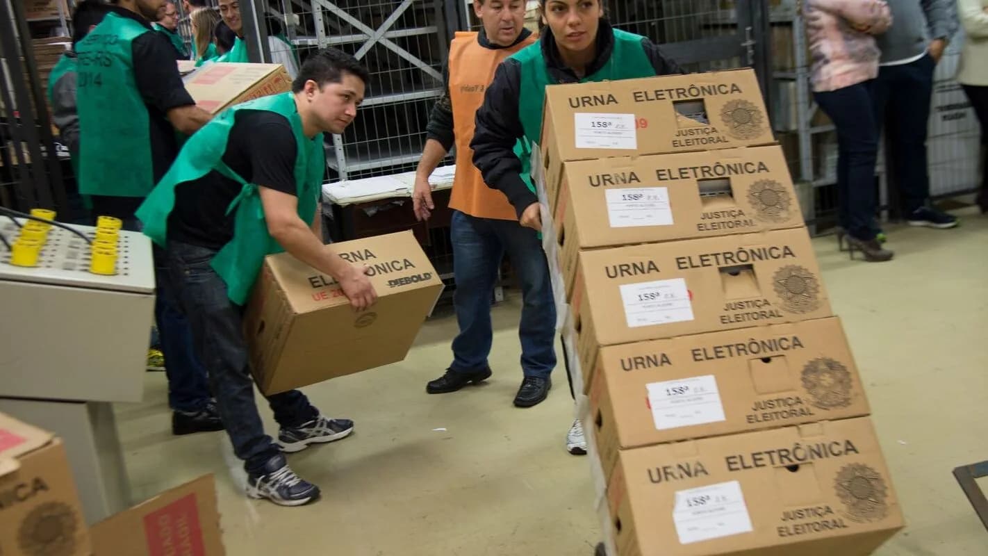 Urnas eletrônicas sendo manuseadas por agentes da Polícia Federal