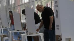Eleitores votando em cabines eleitorais durante o pleito