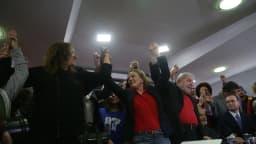Presidente Lula em coletiva de imprensa, gesticulando ao lado de apoiadores