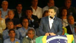 Aécio Neves discursa em convenção do PSDB, com bandeira do Brasil ao fundo