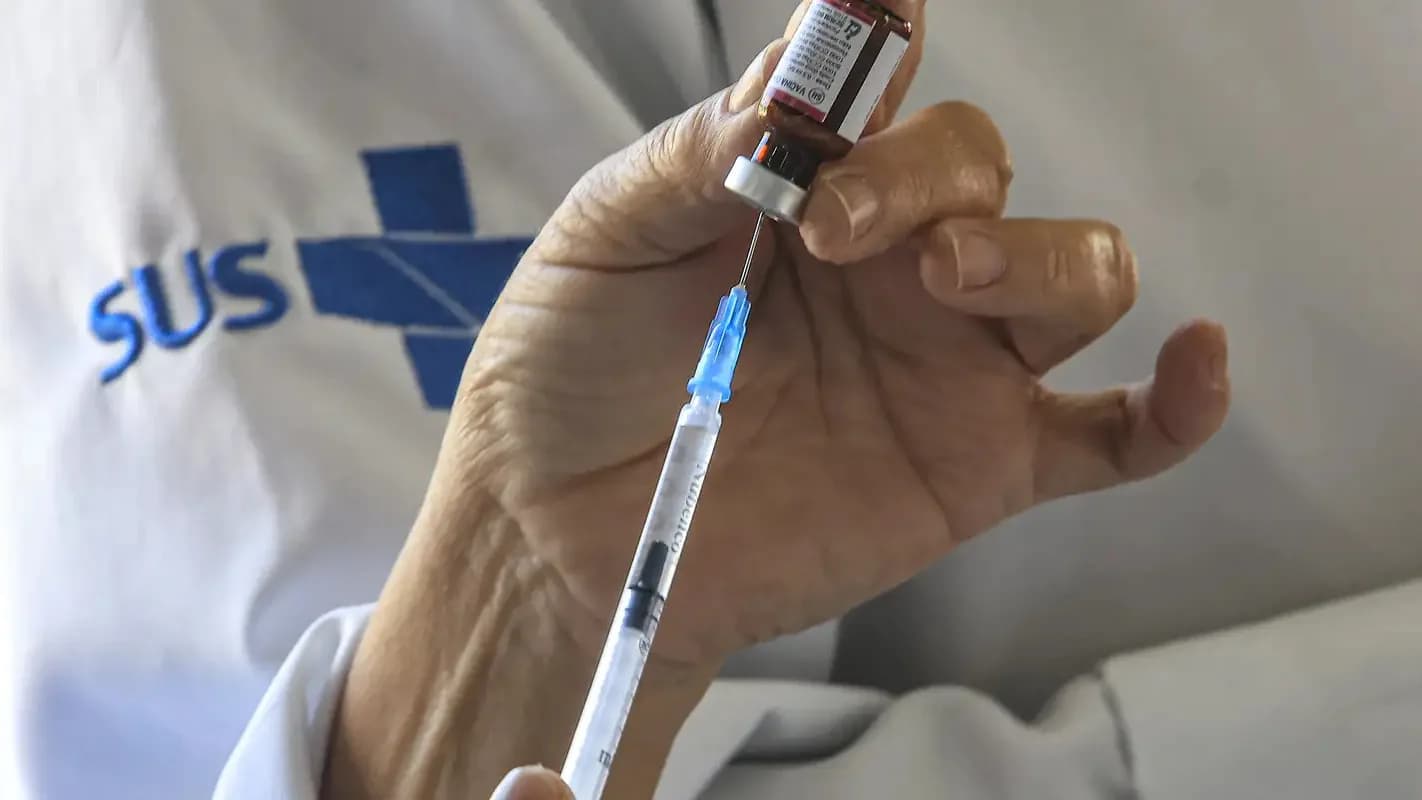 Profissional de saúde prepara uma dose de vacina; foto de arquivo sobre vacinação, sem mostrar a MenQuadfi.