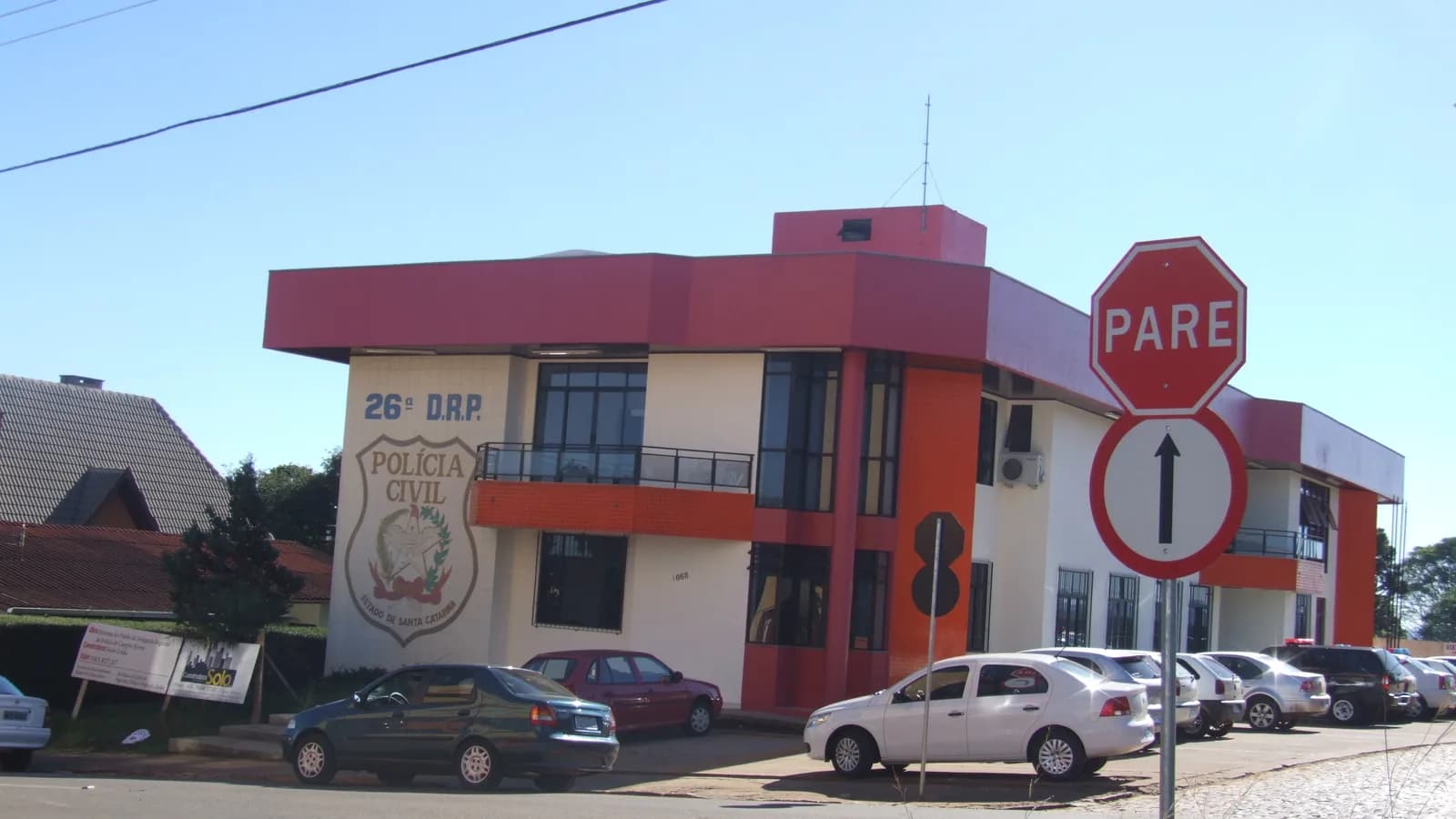 Fachada de delegacia da Polícia Civil de Santa Catarina, com viatura estacionada