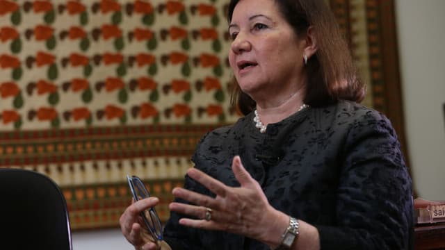 Embaixadora Maria Luiza Ribeiro Viotti gesticula durante entrevista, vestindo blazer preto e colar de pérolas