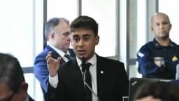 O deputado federal Nikolas Ferreira discursa em microfone durante sessão de comissão no Congresso
