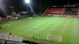 Foto de arquivo do Estádio Barradão à noite, com jogadores do Vitória em aquecimento antes de partida