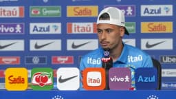 Gabriel Martinelli, de boné branco e camisa azul da seleção brasileira, fala em entrevista coletiva
