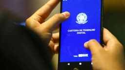 Pessoa segura celular com a tela do aplicativo Carteira de Trabalho Digital aberta