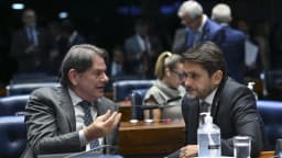 Dois senadores conversam entre as bancadas durante sessão no Plenário do Senado Federal