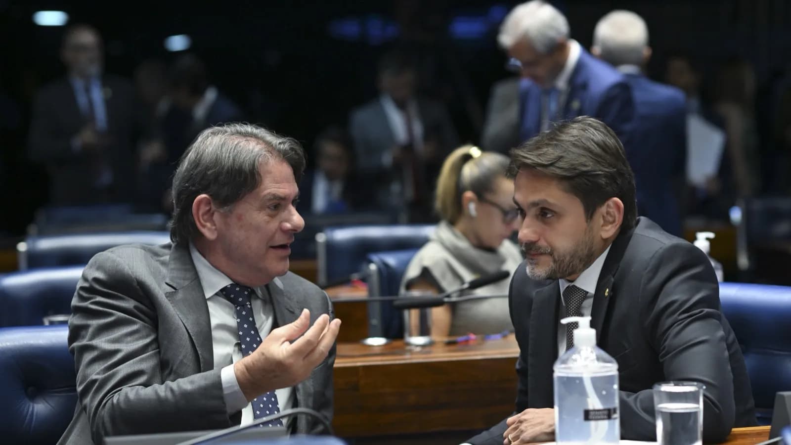 Dois senadores conversam entre as bancadas durante sessão no Plenário do Senado Federal