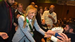 Celina Leão sorri com a faixa de governadora, cumprimentando apoiadores em evento de posse