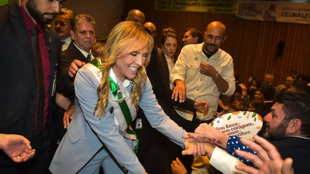 Celina Leão sorri com a faixa de governadora, cumprimentando apoiadores em evento de posse