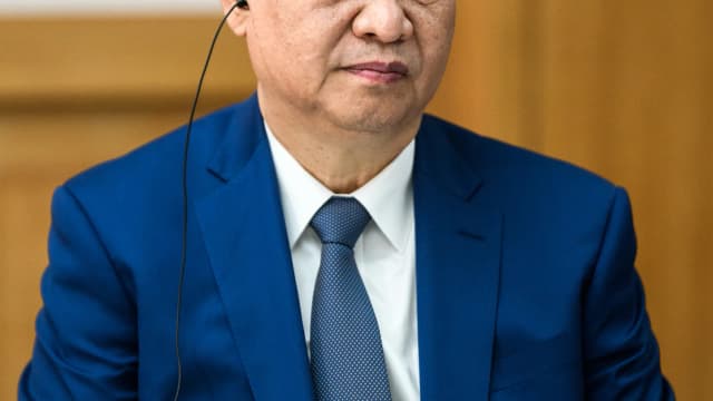 Xi Jinping em desembarque de aeronave, terno azul, cabelo grisalho