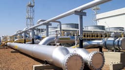 Estação de gasoduto com tubulações de aço e válvulas industriais sob céu azul, em imagem de arquivo