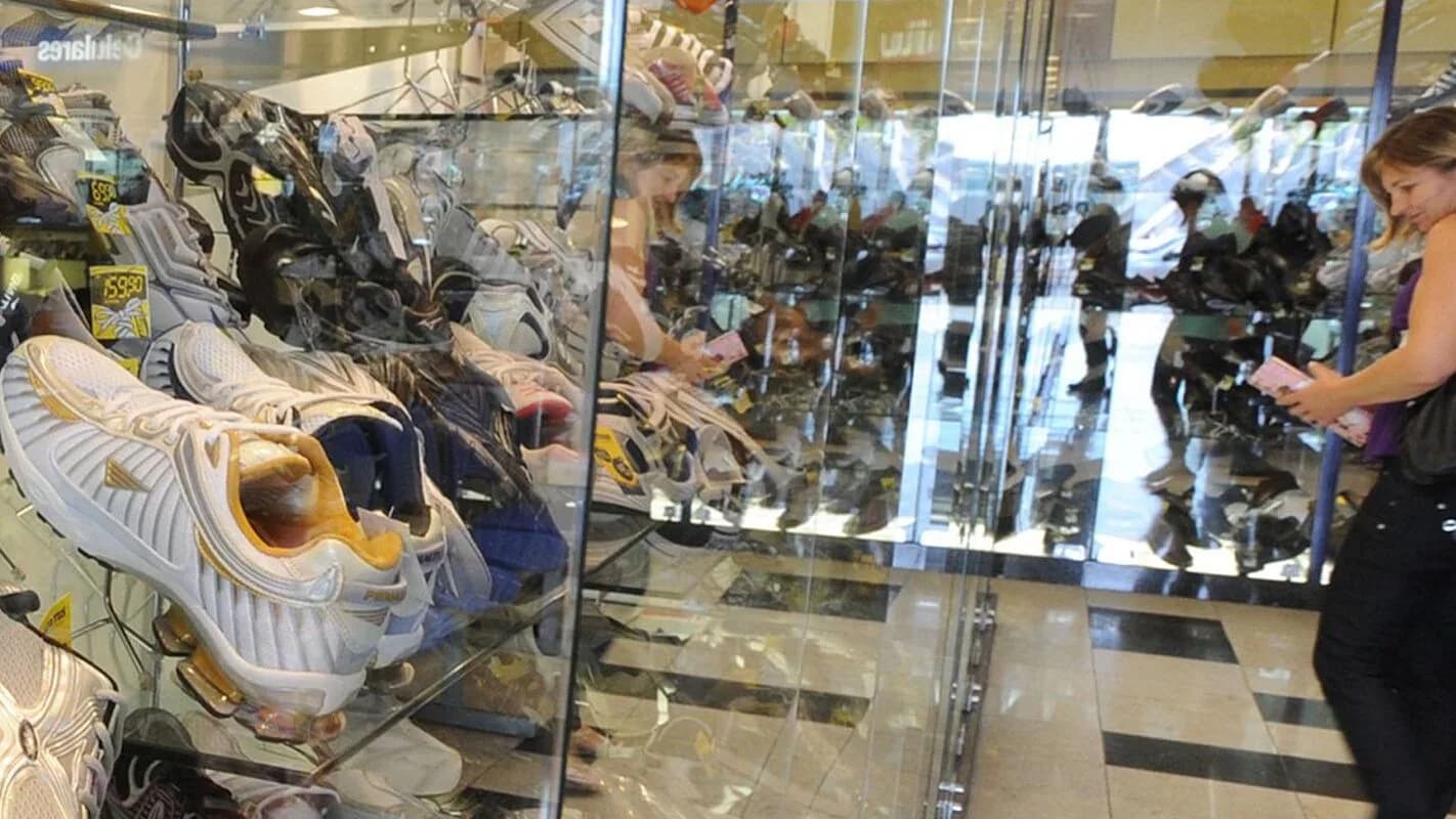 Consumidora observa vitrine de loja em shopping center, foto ilustrativa