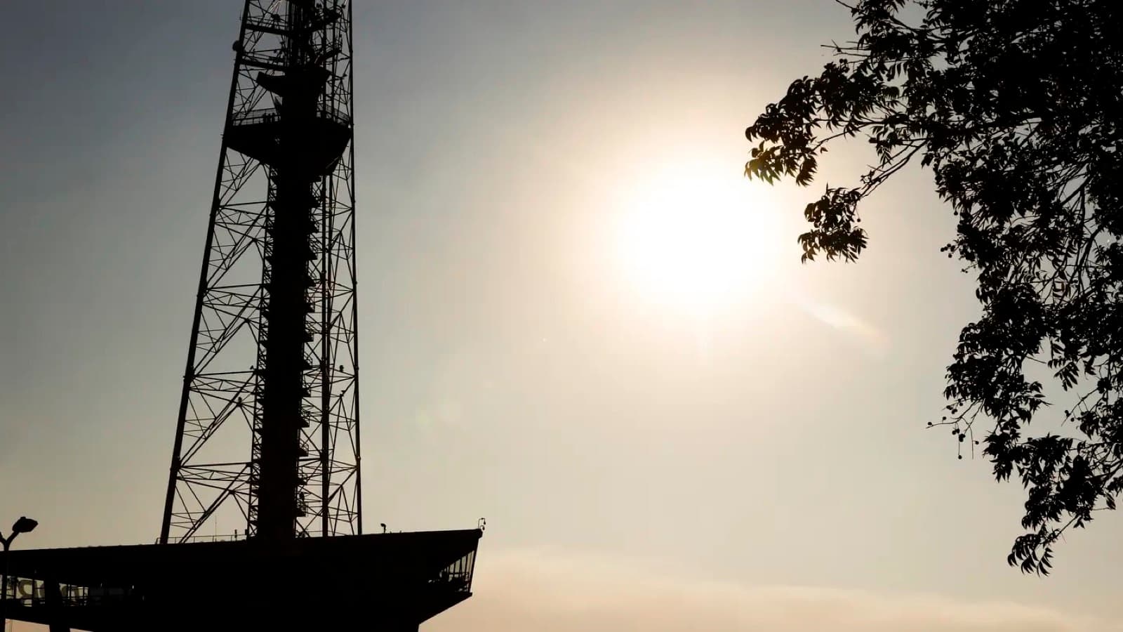 Torre de TV de Brasília em contraluz, com sol forte e céu esbranquiçado de tempo seco, em imagem de arquivo