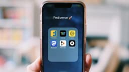 Mão segurando smartphone com ícones de aplicativos na tela