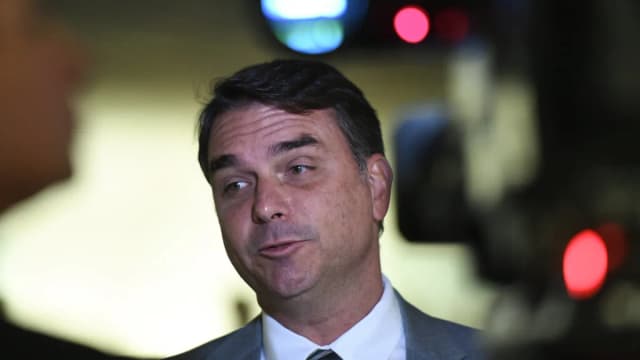 Flávio Bolsonaro fala com jornalistas em área interna do Senado