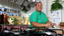 Cozinheira prepara prato em fogão doméstico