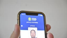Eleitor segura celular com o e-Título aberto no app da Justiça Eleitoral