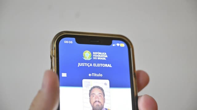 Eleitor segura celular com o e-Título aberto no app da Justiça Eleitoral