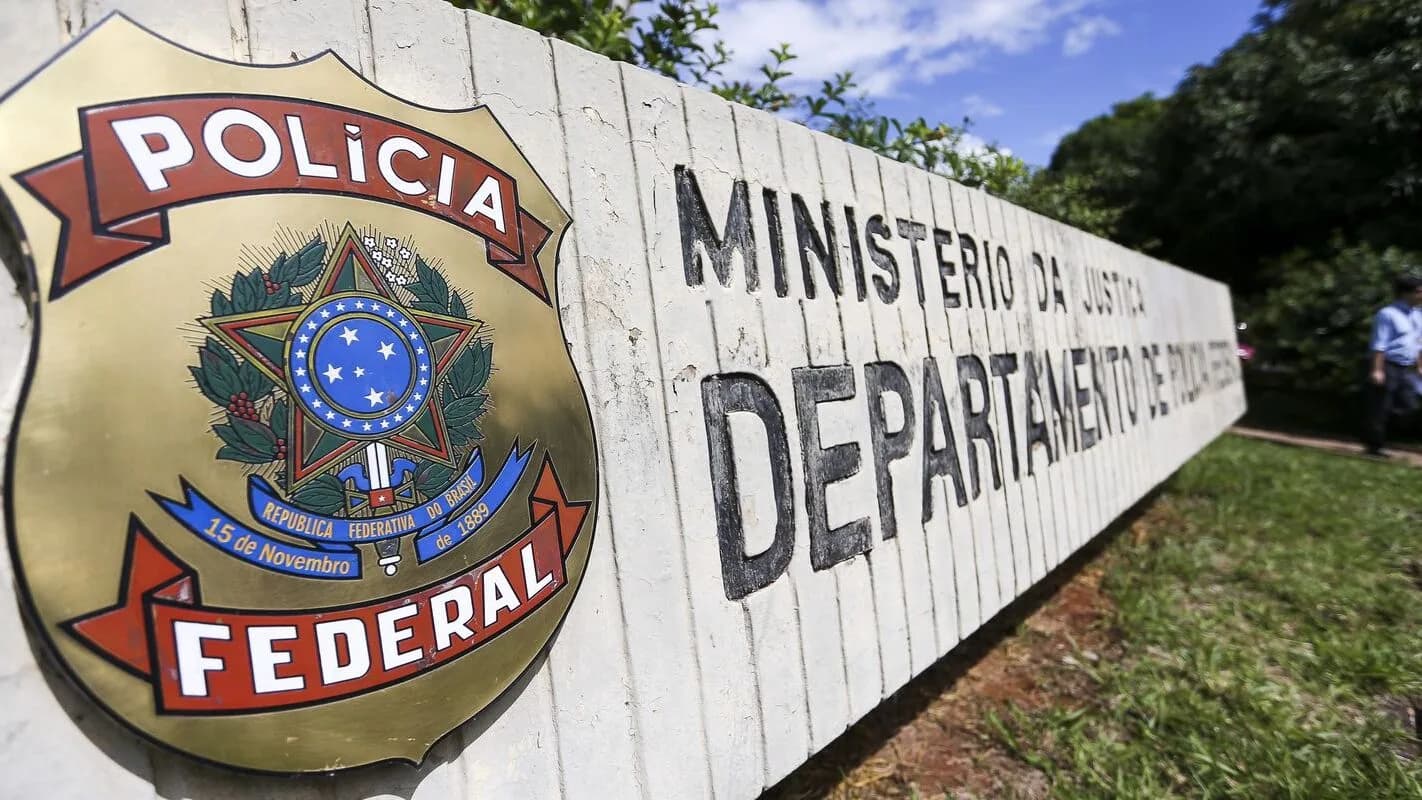 Placa da Polícia Federal e do Departamento de Polícia Federal em muro de concreto