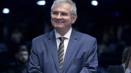 Senador Angelo Coronel sorri em terno no plenário do Senado