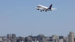 Avião decolando sobre o horizonte de uma cidade