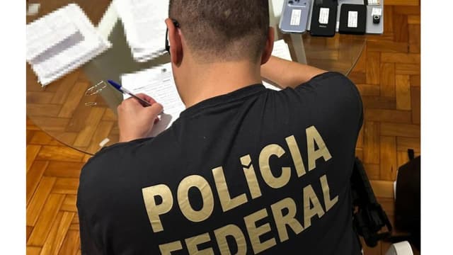 Agente da Polícia Federal documenta material durante operação (foto de arquivo de outra operação da PF)