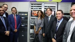 Autoridades visitam sala de equipamentos de telecomunicações com racks de servidores