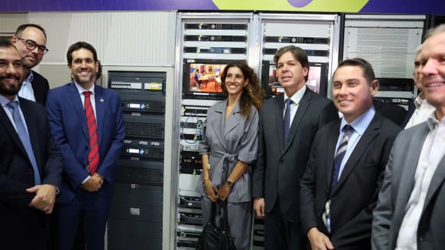 Autoridades visitam sala de equipamentos de telecomunicações com racks de servidores
