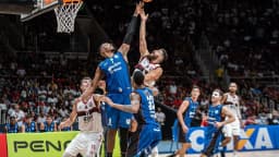 Jogadores disputam bola sob a cesta em partida de basquete (foto de arquivo/contexto)