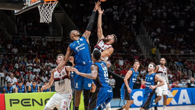 Jogadores disputam bola sob a cesta em partida de basquete (foto de arquivo/contexto)