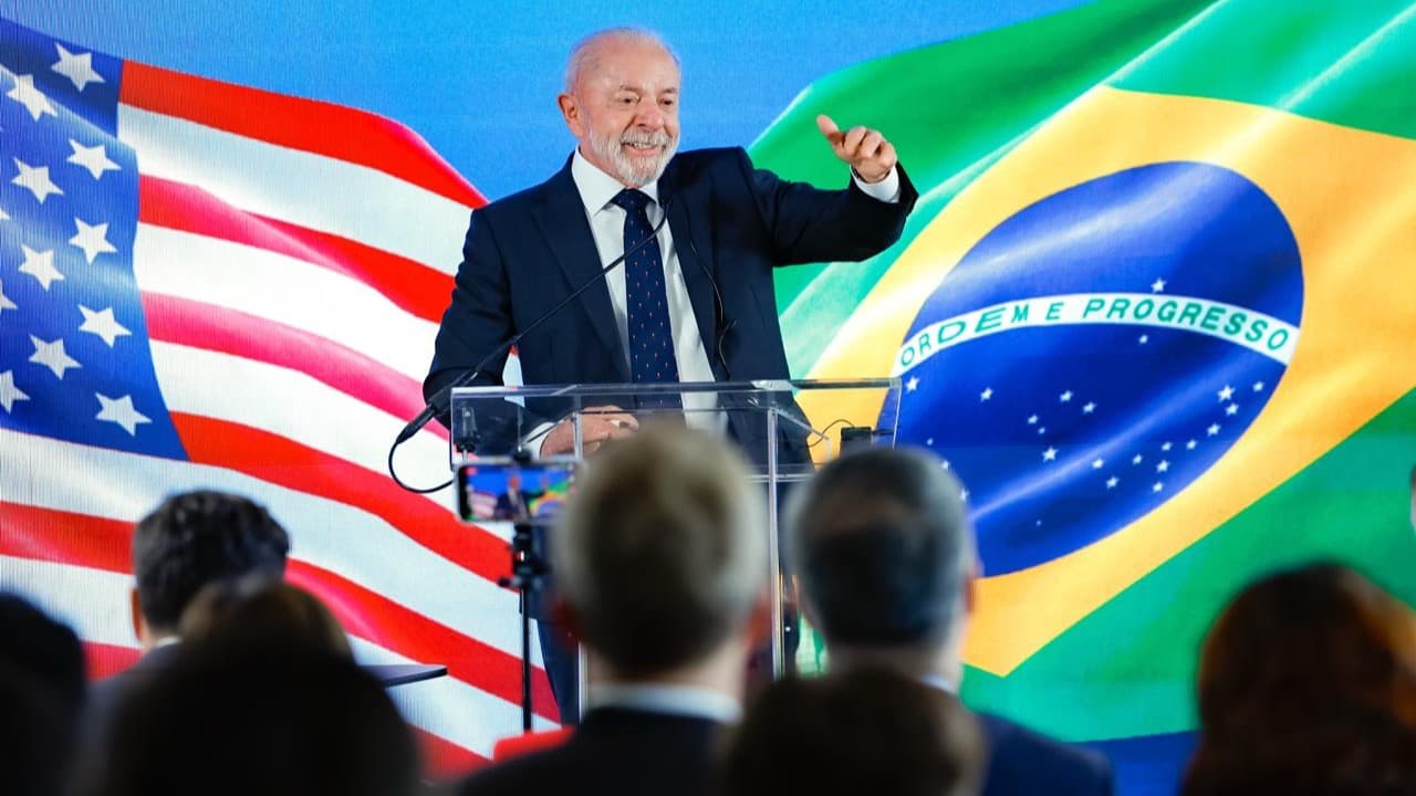 Presidente Lula discursa em púlpito durante coletiva de imprensa em Washington, com bandeiras do Brasil e dos Estados Unidos ao fundo (imagem de arquivo, maio de 2026)