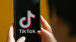 Pessoa segura celular com o aplicativo do TikTok aberto na tela