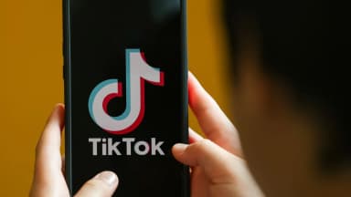 Pessoa segura celular com o aplicativo do TikTok aberto na tela