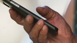 Close de mãos segurando um smartphone na horizontal