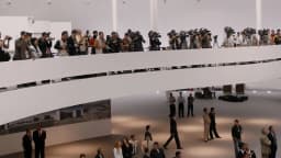 Interior do Museu Nacional da República, em Brasília, com visitantes e fotógrafos reunidos sob o teto em forma de disco