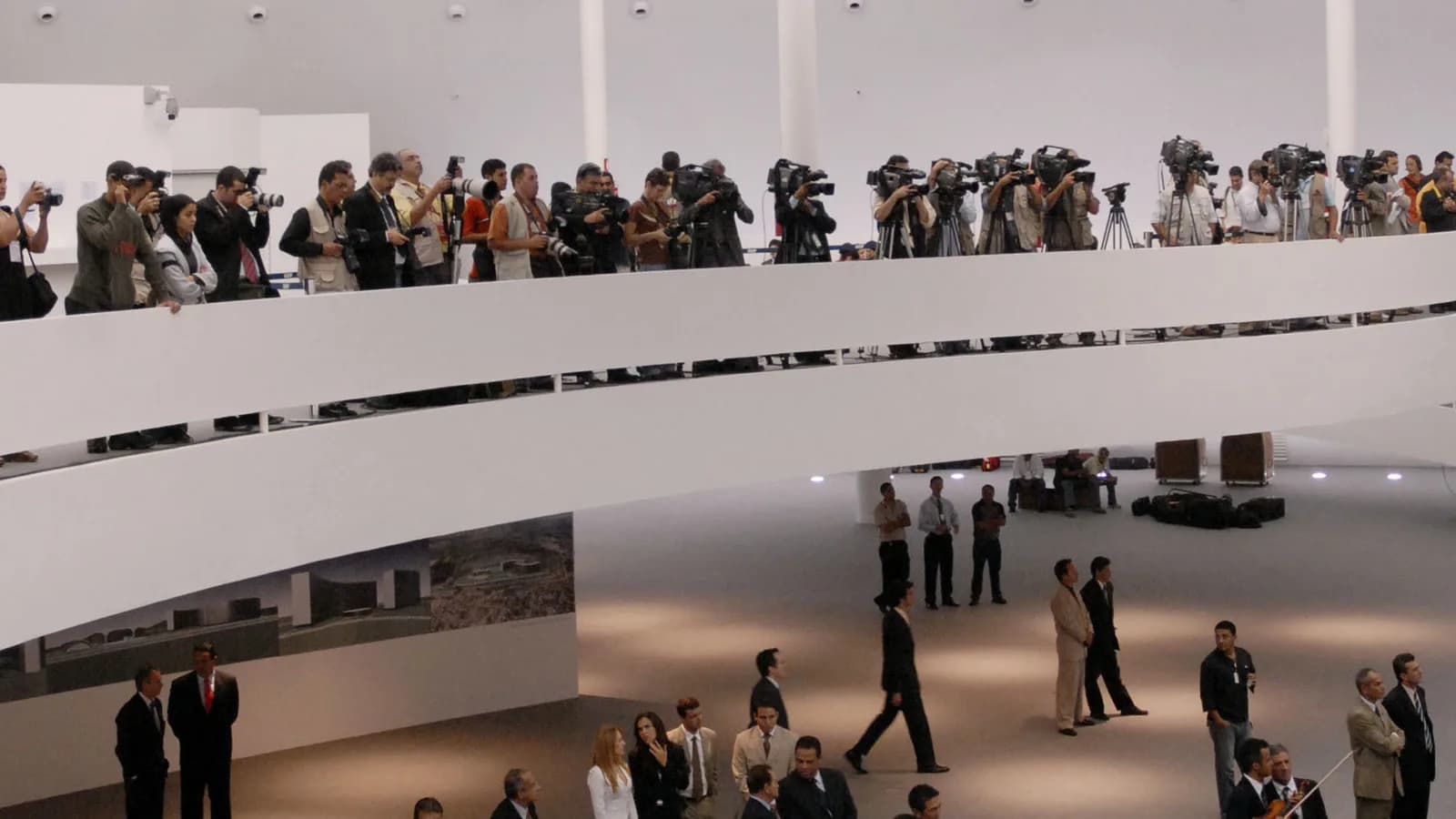 Interior do Museu Nacional da República, em Brasília, com visitantes e fotógrafos reunidos sob o teto em forma de disco