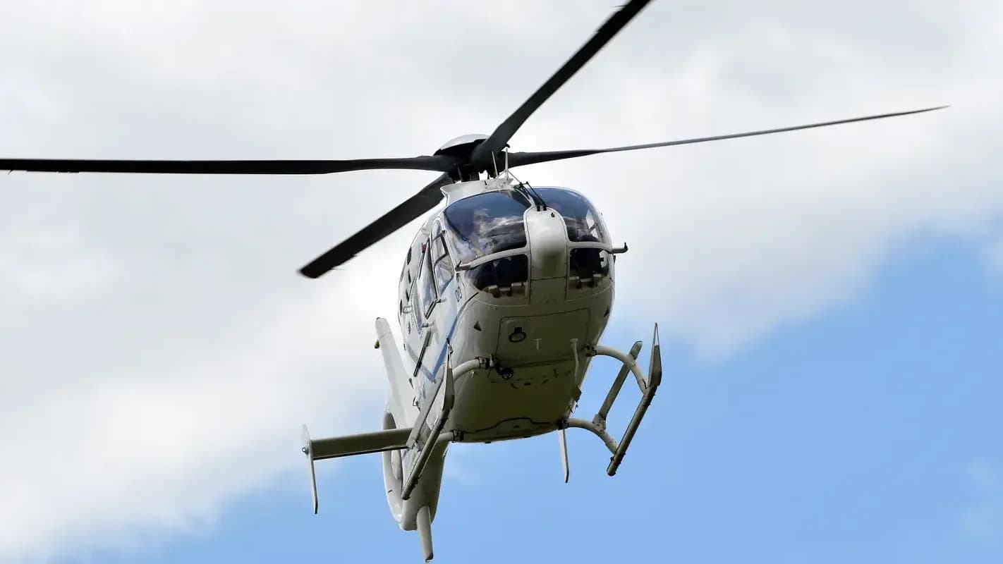 Helicóptero em voo contra o céu azul, foto de arquivo