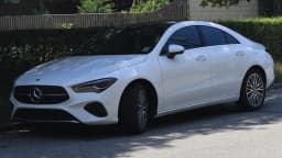 Mercedes-Benz CLA branco, novo modelo, visto de frente em ambiente externo