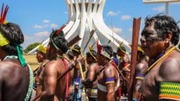 Indígenas com adornos tradicionais reunidos em ato em Brasília