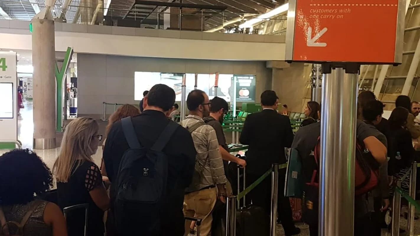 Passageiros fazem fila de embarque com bagagem de mão em aeroporto (foto de arquivo, 2018)