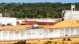 Imagem de arquivo de 2017: vista externa do Complexo Penal de Alcaçuz, em Nísia Floresta (RN), com muro alto de concreto, guarita e contêineres instalados na área interna