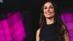 Bianca Andrade sorri em evento, com cabelo solto e vestido preto (foto de arquivo)