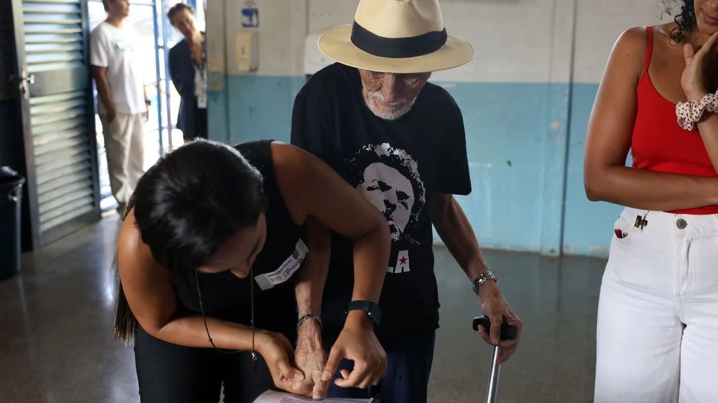 Eleitores de diferentes idades votam em seção eleitoral
